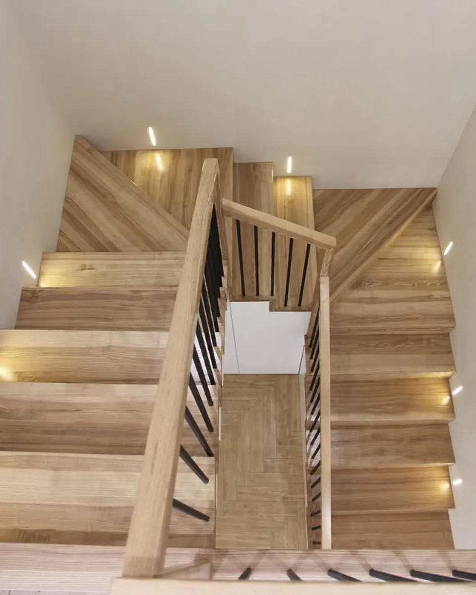 LED-lit oak staircase over herringbone floor in a Seattle home